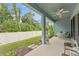 Covered patio featuring outdoor seating, ceiling fan, and a serene view of the green backyard at 1237 Windy Bay Shl, Tarpon Springs, FL 34689