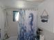 Bright bathroom featuring tiled walls and a decorative, themed shower curtain at 1250 S Pinellas Ave # 1013, Tarpon Springs, FL 34689