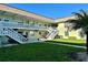 Exterior shot of a two-story light-green building with stairs and a well-maintained lawn at 1250 S Pinellas Ave # 1013, Tarpon Springs, FL 34689