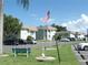 Exterior view of building with colorful landscaping, parking and flagpole with US flag at 1250 S Pinellas Ave # 1013, Tarpon Springs, FL 34689