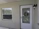 Exterior view of front door with security screen, wreath, and adjacent window at 1250 S Pinellas Ave # 1013, Tarpon Springs, FL 34689