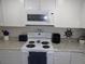 Bright kitchen features white appliances, granite counters, and decorative nautical theme at 1250 S Pinellas Ave # 1013, Tarpon Springs, FL 34689