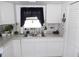 Bright white kitchen with stainless sink, white cabinets, and nautical decor at 1250 S Pinellas Ave # 1013, Tarpon Springs, FL 34689
