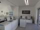Bright community laundry room with washers, folding table and signage at 1250 S Pinellas Ave # 1013, Tarpon Springs, FL 34689