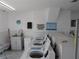 Bright laundry room featuring multiple modern washing machines, sink with white cabinetry, and tiled floors at 1250 S Pinellas Ave # 1013, Tarpon Springs, FL 34689