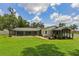 Expansive backyard view showcasing a screened pool, lush lawn, and patio area at 126 Holly Tree Ln, Brandon, FL 33511