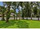 Green backyard featuring mature trees, green grass, and white fence boundary at 126 Holly Tree Ln, Brandon, FL 33511