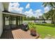 Spacious backyard featuring lush lawn, screened porch, deck, and recreational equipment at 126 Holly Tree Ln, Brandon, FL 33511
