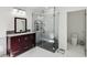 Modern bathroom with glass shower, dark wood vanity, and white tile flooring at 126 Holly Tree Ln, Brandon, FL 33511