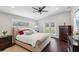 Elegant bedroom with a plush bed, dark hardwood floors, and modern ceiling fan at 126 Holly Tree Ln, Brandon, FL 33511