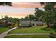 Charming single story home with a manicured lawn, garden beds, and a long driveway at 126 Holly Tree Ln, Brandon, FL 33511