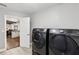 Modern washer and dryer appliances sit in a laundry room with an open doorway to another room at 126 Holly Tree Ln, Brandon, FL 33511
