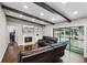 Open-concept living room with fireplace, built-in shelving, exposed beams, and seamless access to the pool area at 126 Holly Tree Ln, Brandon, FL 33511