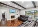 Stylish living area featuring a fireplace, built-ins, exposed beams, and direct access to outdoor spaces at 126 Holly Tree Ln, Brandon, FL 33511