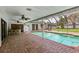 Outdoor pool area featuring ceiling fans, a bar, and brick pavers, perfect for outdoor entertaining at 126 Holly Tree Ln, Brandon, FL 33511