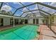 Aerial pool view with covered enclosure, brick trim, and connection to outdoor living at 126 Holly Tree Ln, Brandon, FL 33511