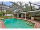 Inviting screened-in pool area with a brick patio and ample space for outdoor entertaining at 126 Holly Tree Ln, Brandon, FL 33511