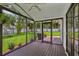 Inviting screened porch with wood flooring, ceiling fan, and peaceful backyard views at 126 Holly Tree Ln, Brandon, FL 33511
