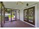 Relaxing screened porch featuring a ceiling fan, wood flooring, and outdoor access at 126 Holly Tree Ln, Brandon, FL 33511