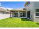 Expansive backyard showcasing a covered patio and the home's rear facade with large sliding glass doors at 12801 Stanwyck Cir, Tampa, FL 33626