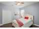 Bedroom featuring a bed with a red throw and pillows, a painting of a bridge, and a closet at 12801 Stanwyck Cir, Tampa, FL 33626