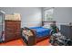 Bedroom with wood floors, a large dresser, a dark wood bed with blue bedding, and a window with blinds at 12801 Stanwyck Cir, Tampa, FL 33626