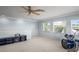 Bright upstairs bonus room with neutral carpet, a ceiling fan and two windows that provide lots of light at 12801 Stanwyck Cir, Tampa, FL 33626