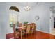 Dining room with hardwood floors, large windows, decorative lighting, and seating for six at 12801 Stanwyck Cir, Tampa, FL 33626