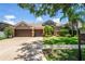 Charming home featuring a well-manicured lawn, a three-car garage, and mature landscaping, showcasing curb appeal at 12801 Stanwyck Cir, Tampa, FL 33626