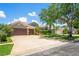 Charming single-story home with a well-manicured lawn, mature trees, and a spacious driveway at 12801 Stanwyck Cir, Tampa, FL 33626