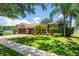 Beautiful single-story home with a large garage, manicured lawn, and lush landscaping in a serene setting at 12801 Stanwyck Cir, Tampa, FL 33626