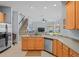 Bright kitchen showing stainless appliances, a breakfast bar, and a view of the staircase and living area at 12801 Stanwyck Cir, Tampa, FL 33626