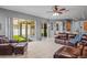 Spacious living room featuring tile floors, sliding doors to backyard, and comfortable leather furniture at 12801 Stanwyck Cir, Tampa, FL 33626