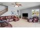 Living room features a leather sofa, ceiling fan, staircase and tile flooring at 12801 Stanwyck Cir, Tampa, FL 33626