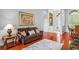 Spacious living room featuring hardwood floors, leather furniture and an arched doorway to the foyer at 12801 Stanwyck Cir, Tampa, FL 33626