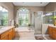 Gorgeous main bathroom featuring separate shower, soaking tub, dual sinks, and a decorative arched window at 12801 Stanwyck Cir, Tampa, FL 33626