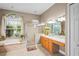 Luxurious main bathroom with garden tub, walk-in shower, double vanities, and large arched window at 12801 Stanwyck Cir, Tampa, FL 33626