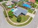Aerial view of a home with green lawn, concrete driveway, and a fenced yard with a pool at 12879 112Th St, Largo, FL 33778