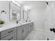 Updated bathroom features a gray vanity with dual sinks, modern mirrors, and marble-patterned floors at 12879 112Th St, Largo, FL 33778