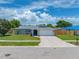 Charming single-story home with a well-manicured lawn, a gray roof, and a two-car garage at 12879 112Th St, Largo, FL 33778