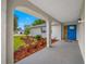 Inviting front porch showcasing an artisan blue door and lush landscaping at 12879 112Th St, Largo, FL 33778