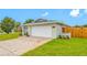 Garage and front yard featuring lawn and garden beds with an American flag at 12879 112Th St, Largo, FL 33778