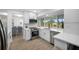 Bright kitchen featuring white cabinets, stainless steel appliances, and a window overlooking the backyard at 12879 112Th St, Largo, FL 33778