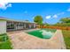Backyard showcasing a sparkling pool, screened lanai, and privacy fence under a bright, sunny sky at 12879 112Th St, Largo, FL 33778