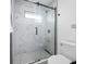 Modern glass shower boasts stylish marble tile and sleek black hardware for a luxurious feel at 12879 112Th St, Largo, FL 33778
