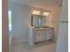 Bathroom featuring a double granite vanity illuminated by modern lighting, enhanced by wood-look tiling at 13334 Ogden Glade Rd, Dade City, FL 33525