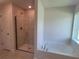 Bright bathroom showcasing a glass shower and soaking tub complemented by tile flooring and neutral paint at 13334 Ogden Glade Rd, Dade City, FL 33525