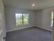 Bright bedroom featuring a large window overlooking manicured landscaping at 13334 Ogden Glade Rd, Dade City, FL 33525