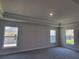 Neutral Primary bedroom with three windows, carpet flooring, and tray ceiling at 13334 Ogden Glade Rd, Dade City, FL 33525