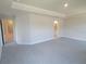 Large carpeted bedroom showcasing a tray ceiling and doorway into an ensuite bathroom at 13334 Ogden Glade Rd, Dade City, FL 33525